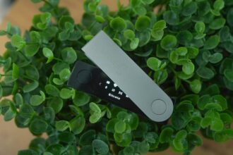 Ein silbernes Ledger Nano Gen 5 Hardware-Wallet, sicher vernetzt mit einem Laptop, schützt Kryptowährungen vor Diebstahl.