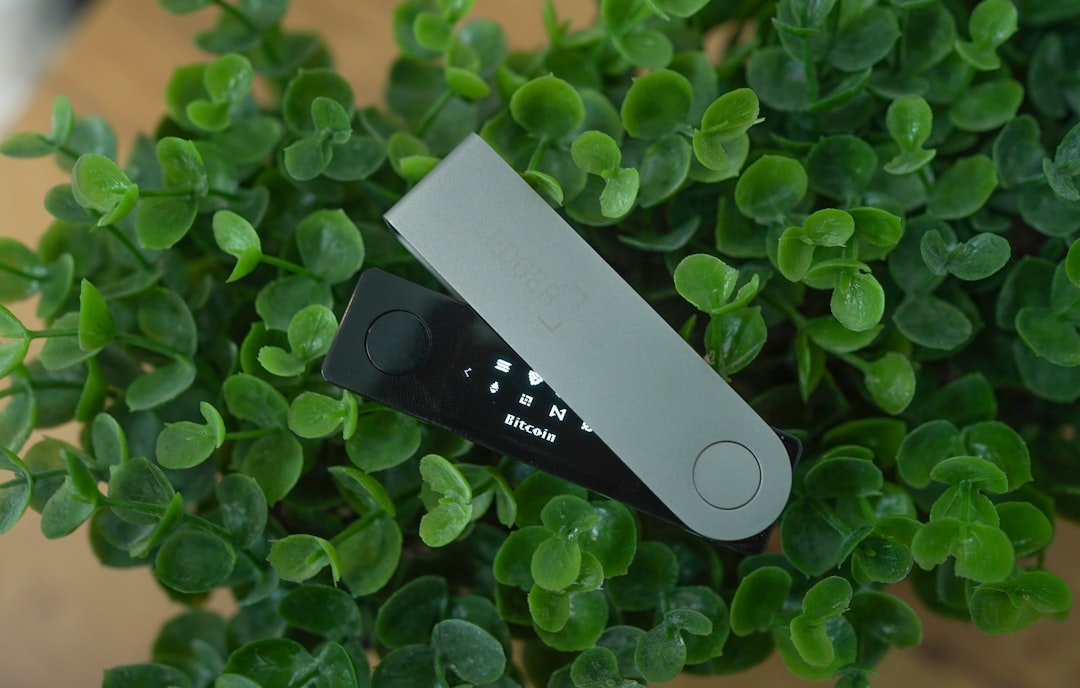 Ein silbernes Ledger Nano Gen 5 Hardware-Wallet, sicher vernetzt mit einem Laptop, schützt Kryptowährungen vor Diebstahl.