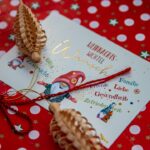 Ein goldener Geschenkgutschein über 100 Euro, verziert mit Tannenzweigen und einer roten Schleife, symbolisiert stressfreies und sparsames Schenken zu Weihnachten.